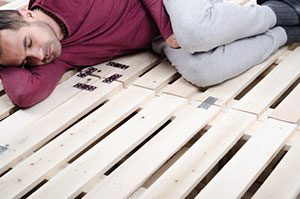 Man Sleeping On Firm Wooden Pallets
